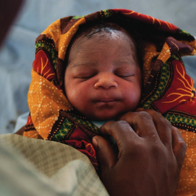 Newborn baby wrapped in colourful cloth